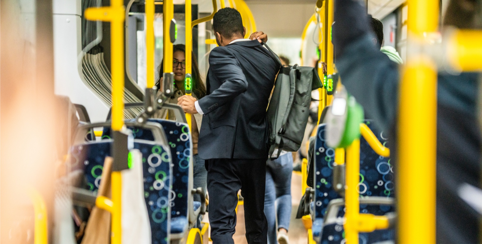 Ein Mann mit Rucksack im Anzug steht mit dem R�cken zum Betrachter im Bus