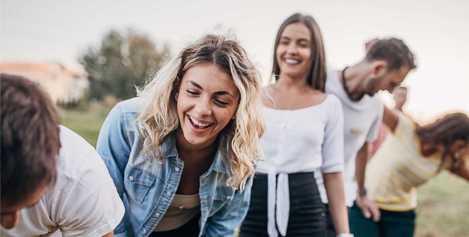 Junge Frau lacht aus einer Reihe junger Menschen