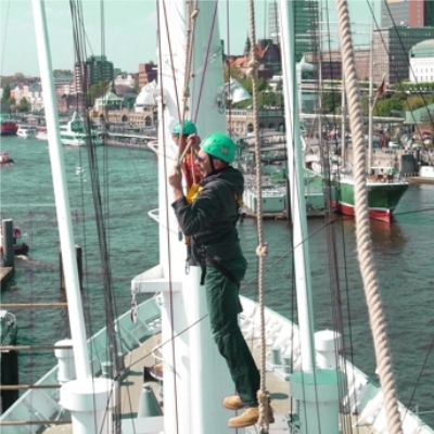 Zwei Teilnehmer balancieren in der Takelage der Cap San Diego