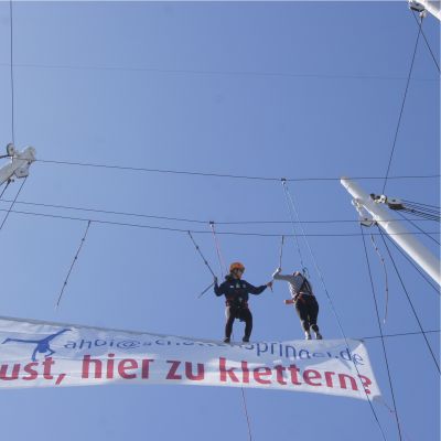 Team-Event Klettern im Hamburger Hafen Aufnahme von unten nach oben zwei Kletterer balancieren in der Takelage des Schiffs Cap San Diego