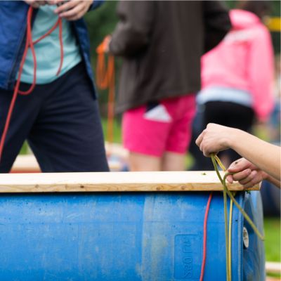 Team-Event Floßbau Abenteuer Nahaufnahme beim Bau eines Floßes
