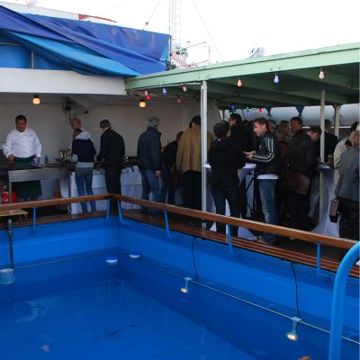 Eine Gruppe auf dem Pooldeck der Cap San Diego beim Essen