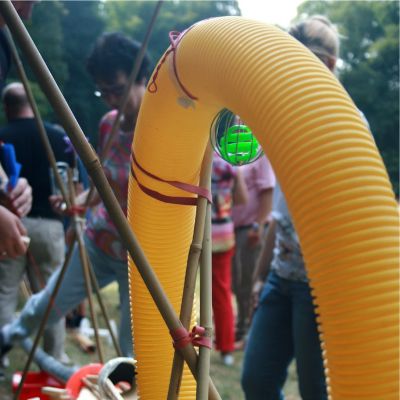 Team-Event Mega Marble Run Nahaufnahme einer großen Kugelbahn mit einem großen gelben Schlauch der einen Looping bildet