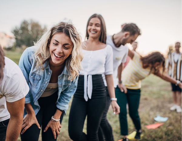 Eine Gruppe Jugendlicher spielt ein Teamspiel und balanciert auf einem vorgegebenen Weg