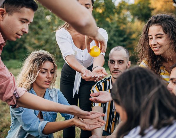 Eine Gruppe junger Erwachsener versuchen gemeinsam ein Teamspiel zu lsen