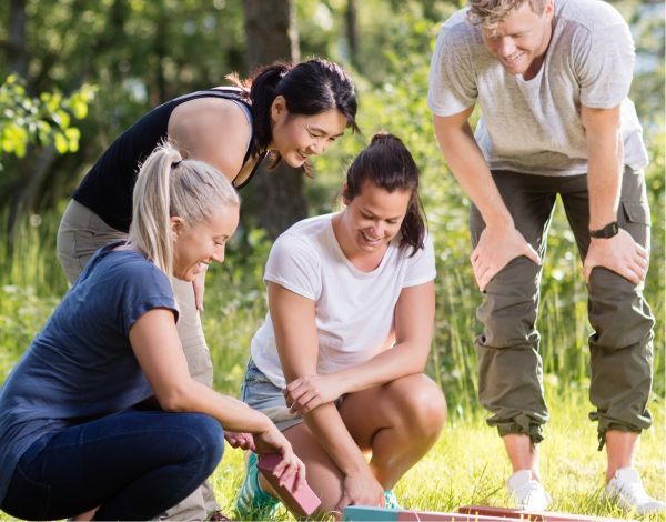 Eine Gruppe Erwachsener versuchen gemeinsam ein Teamspiel zu lsen